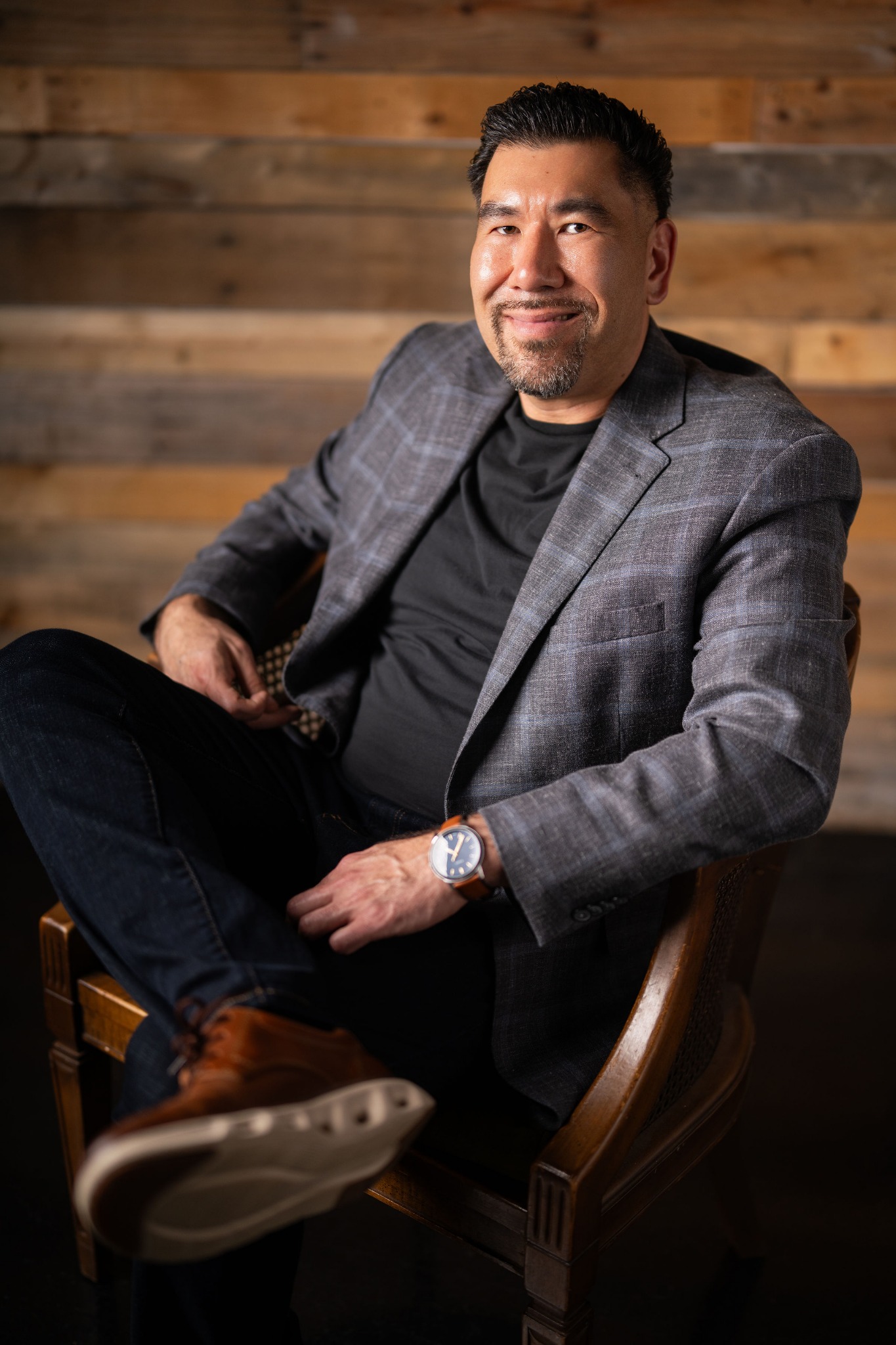Joshua T. Hartnett seated in a patterned blazer