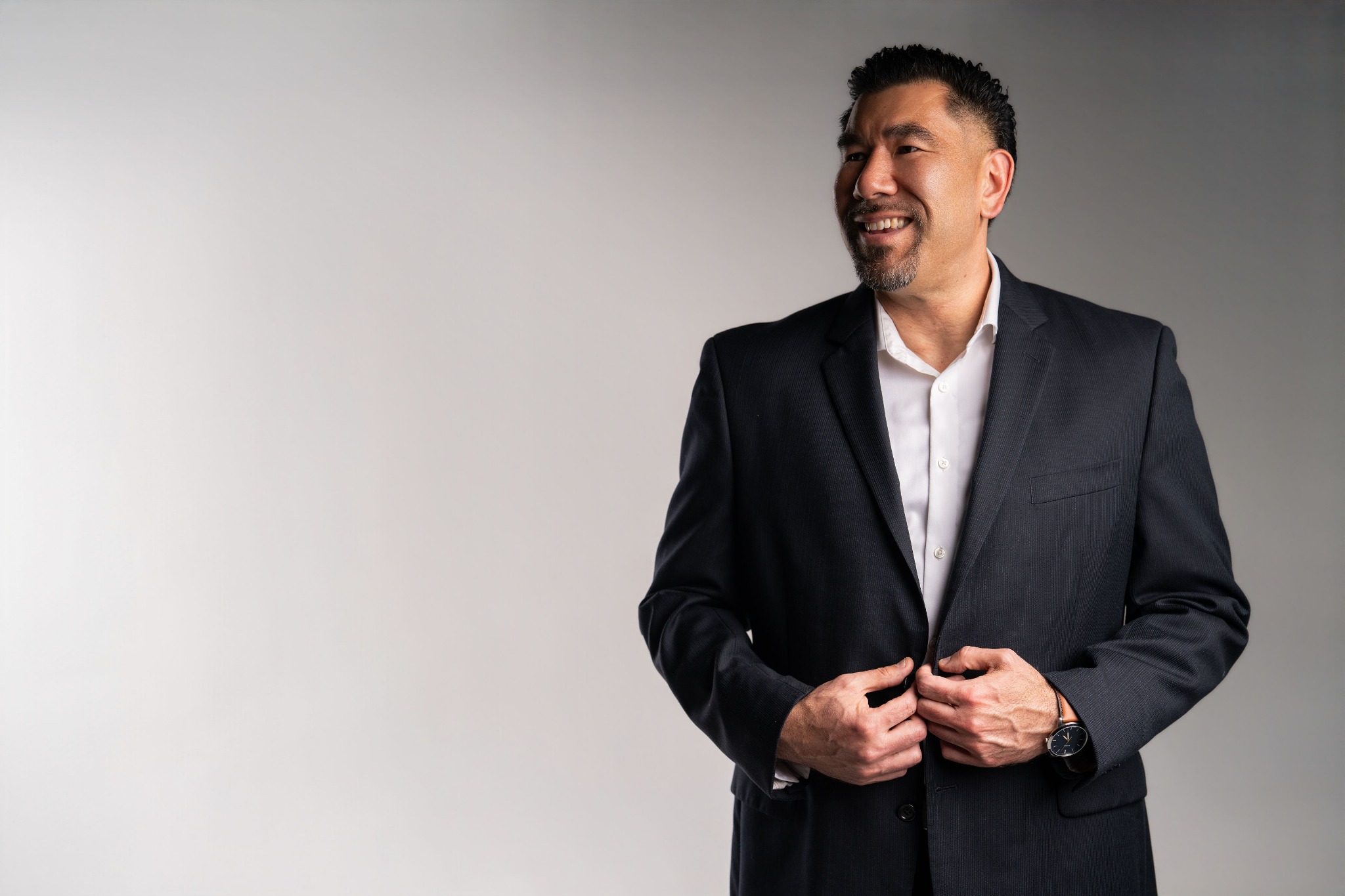 Joshua T. Hartnett smiling in a navy blazer